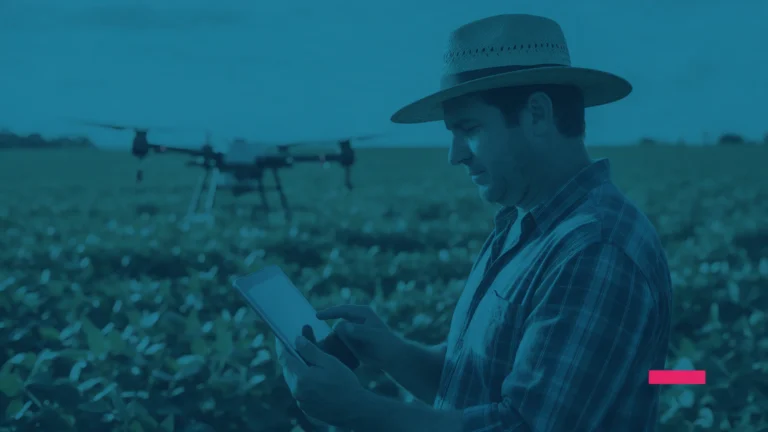 Produtor rural usando um tablet em uma plantação, com um drone ao fundo